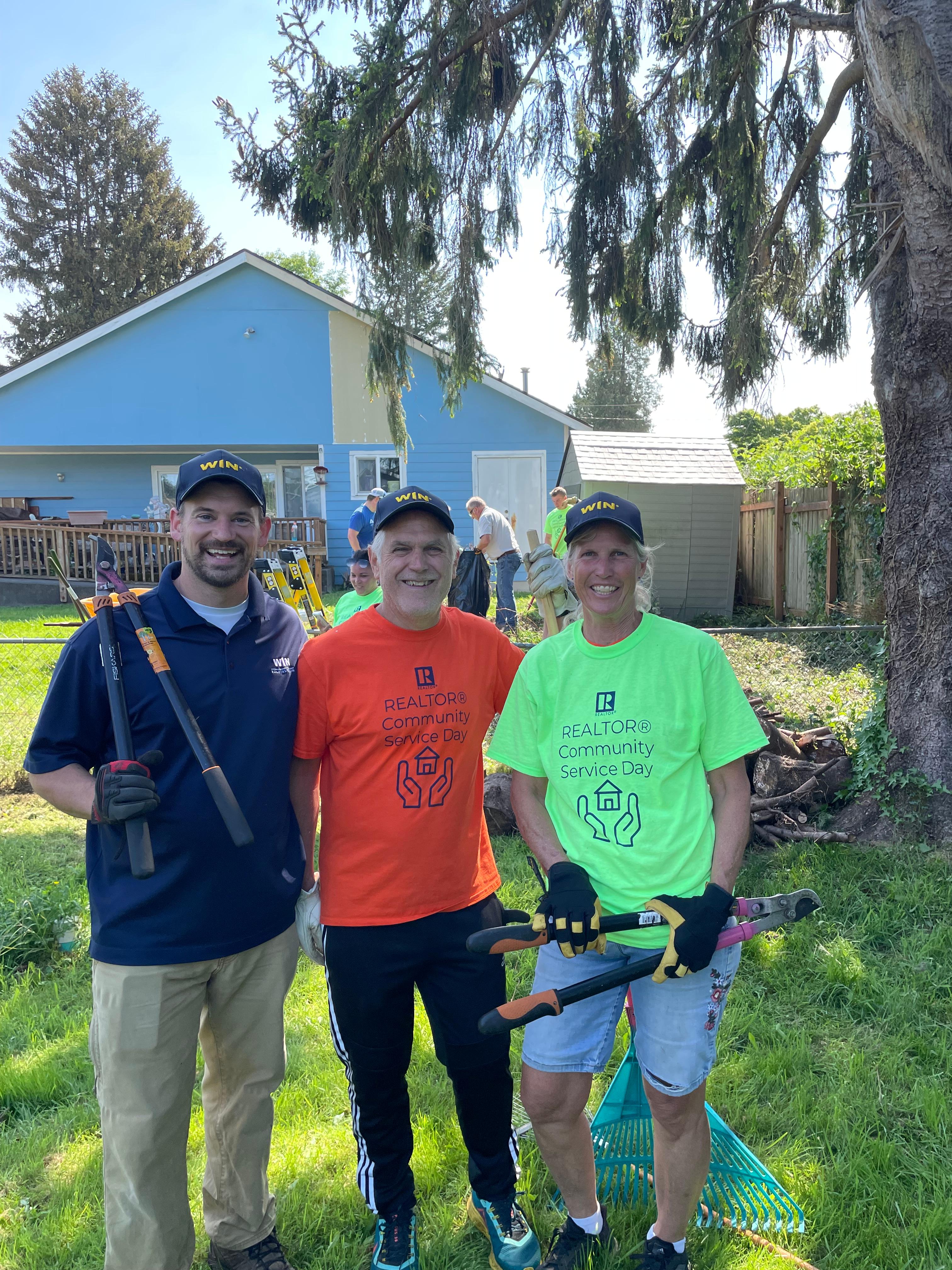 WIN Home Inspection team painting a house from a ladder.