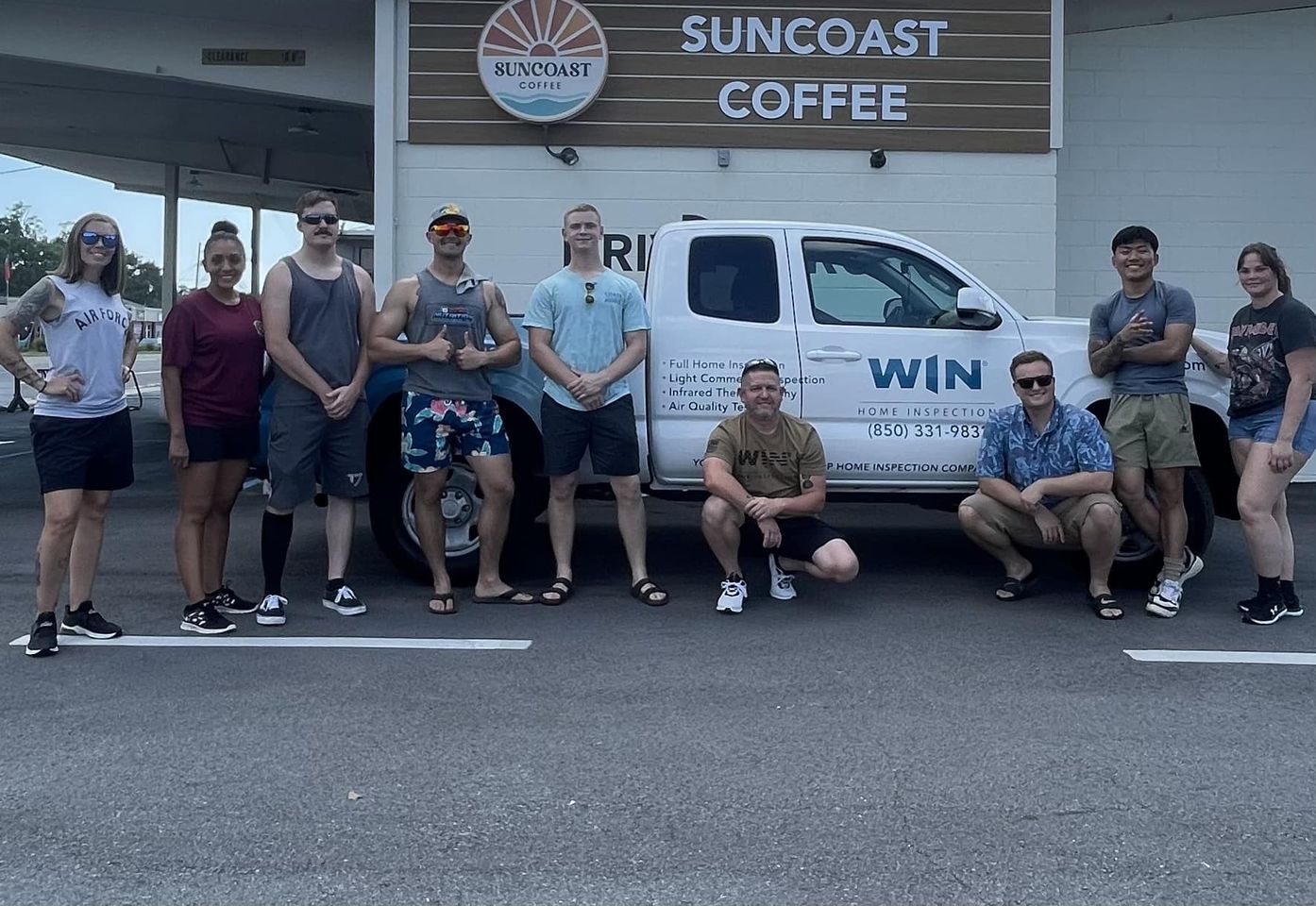 WIN Home Inspection team painting a house from a ladder.