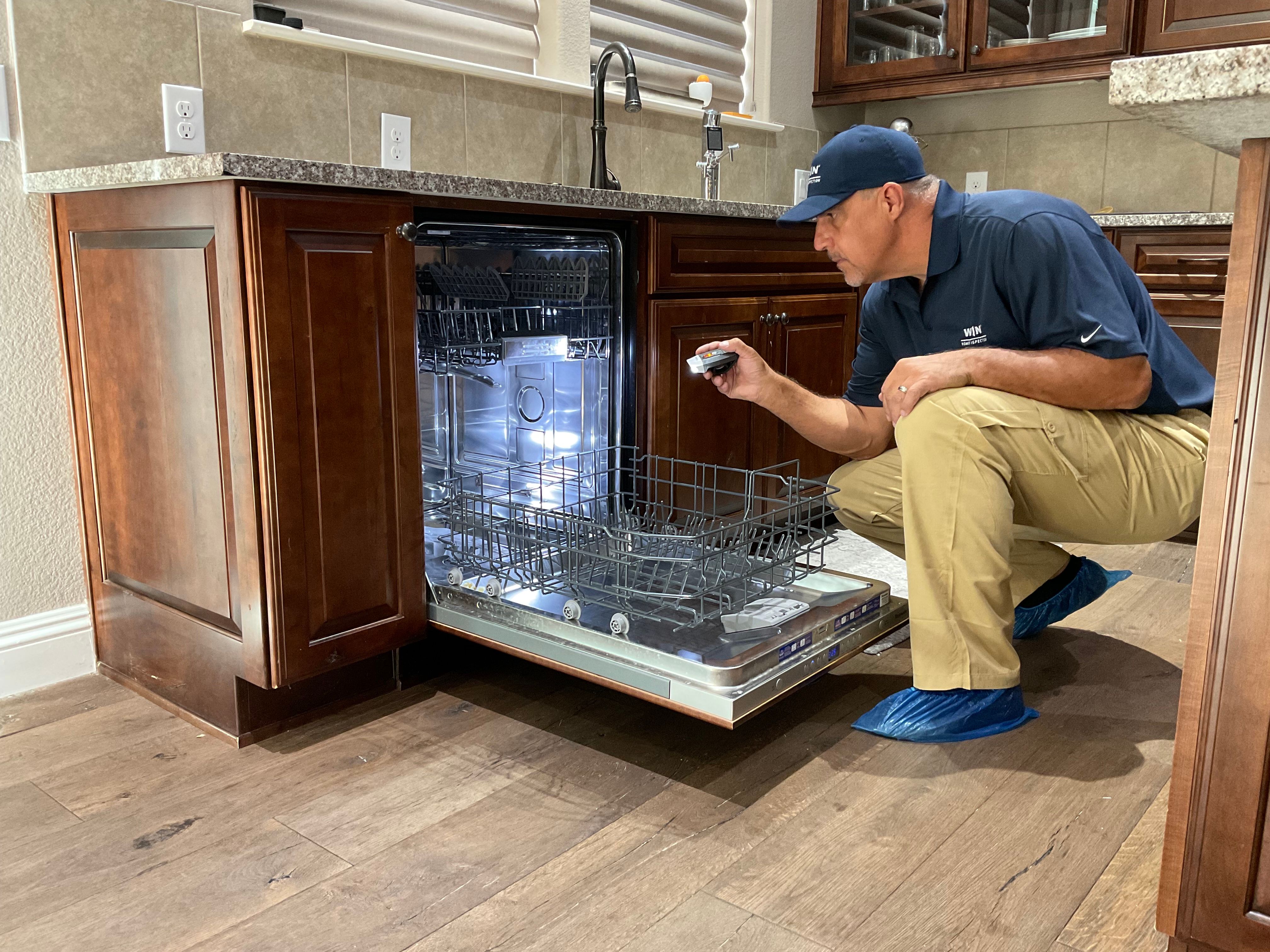 Home inspector inspecting the dishwasher in the kitchen.