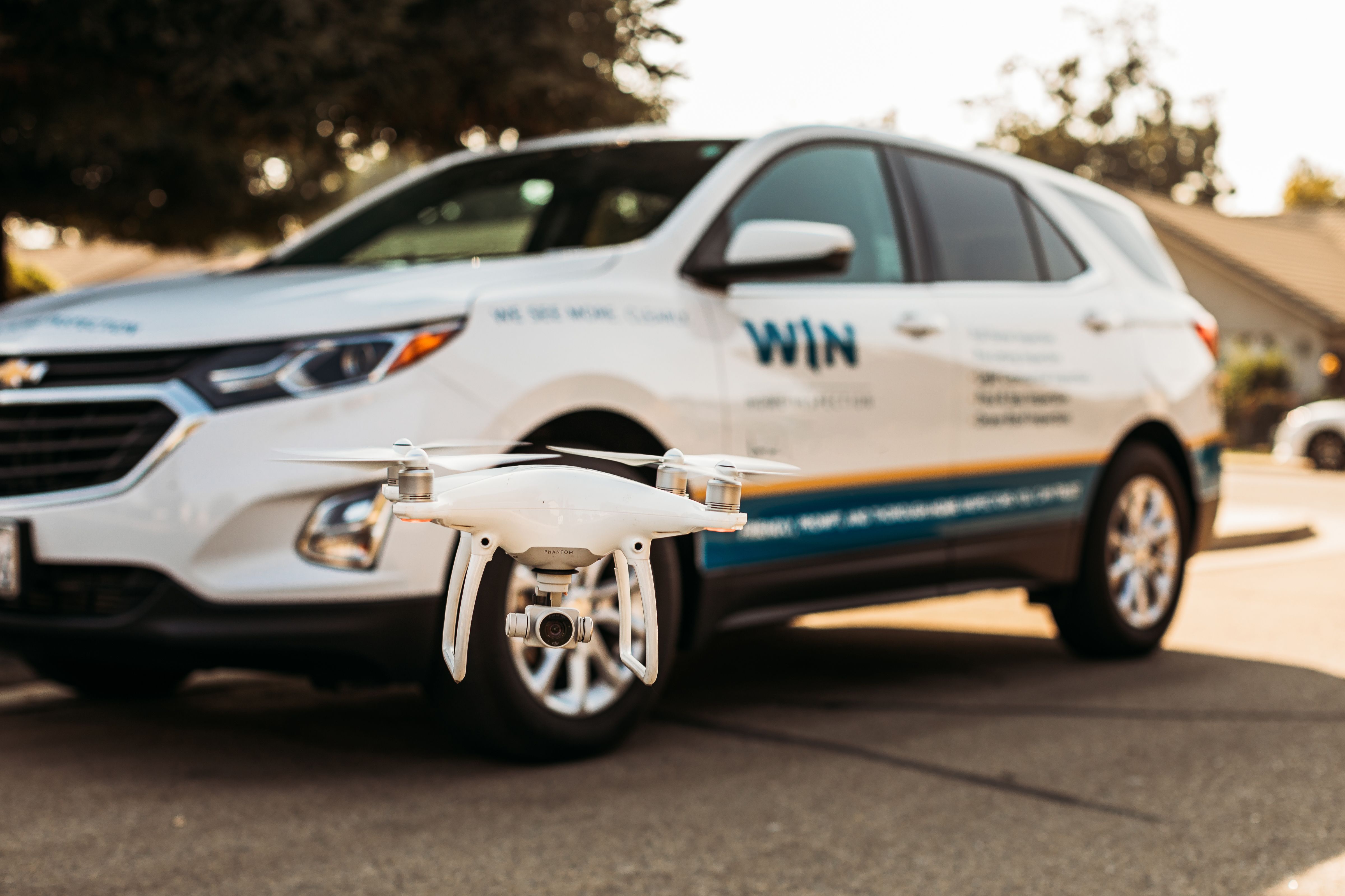 Drone in front of WIN Home Inspector's Car.