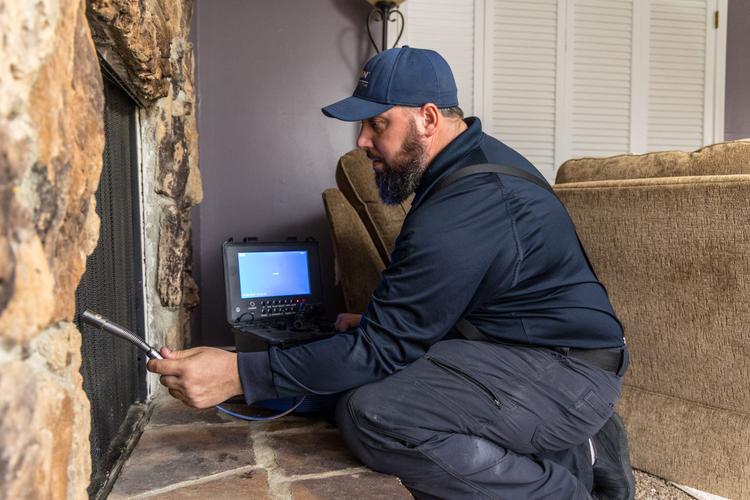 WIN Home Inspector doing a fireplace inspection