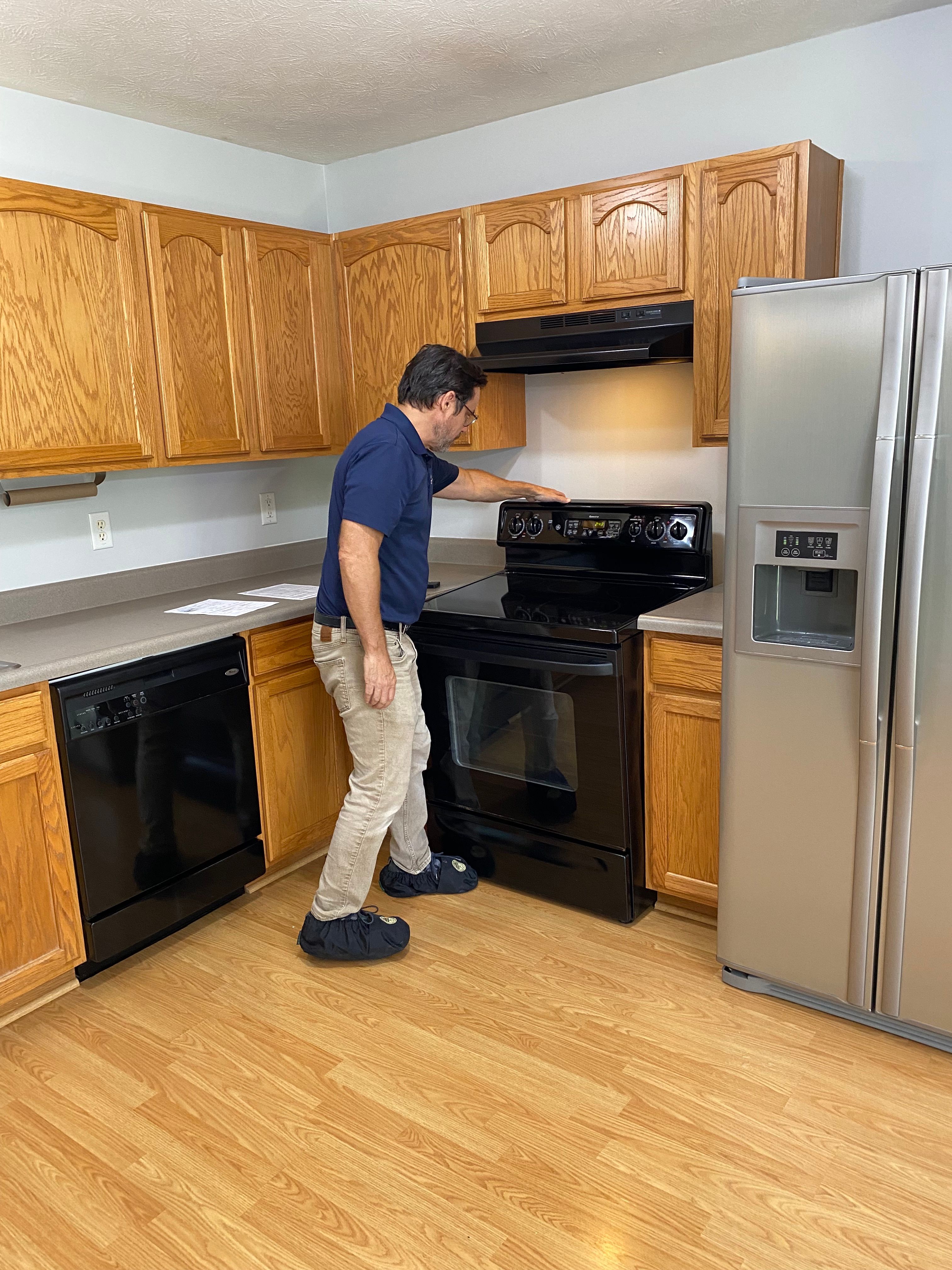 WIN Home Inspector examining a kitchen stove