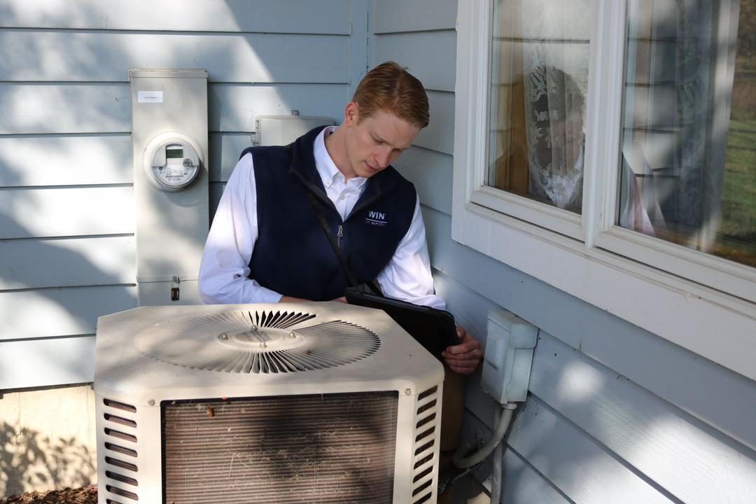 WIN Home Inspector checking AC unit in a duplex