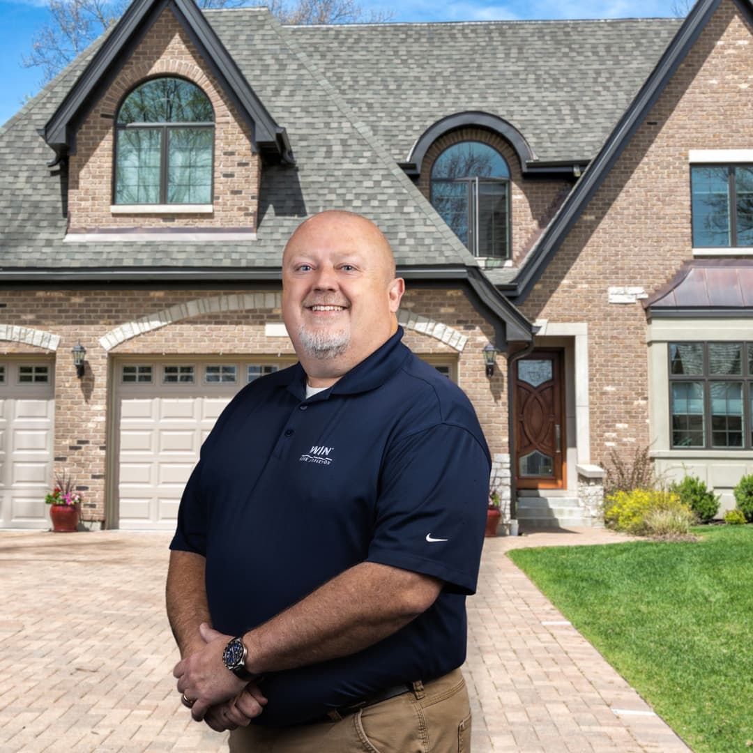 WIN Home Inspector shaking hands with client in front of a house door