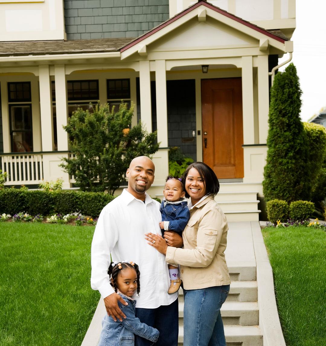 A happy family standing in front of a house