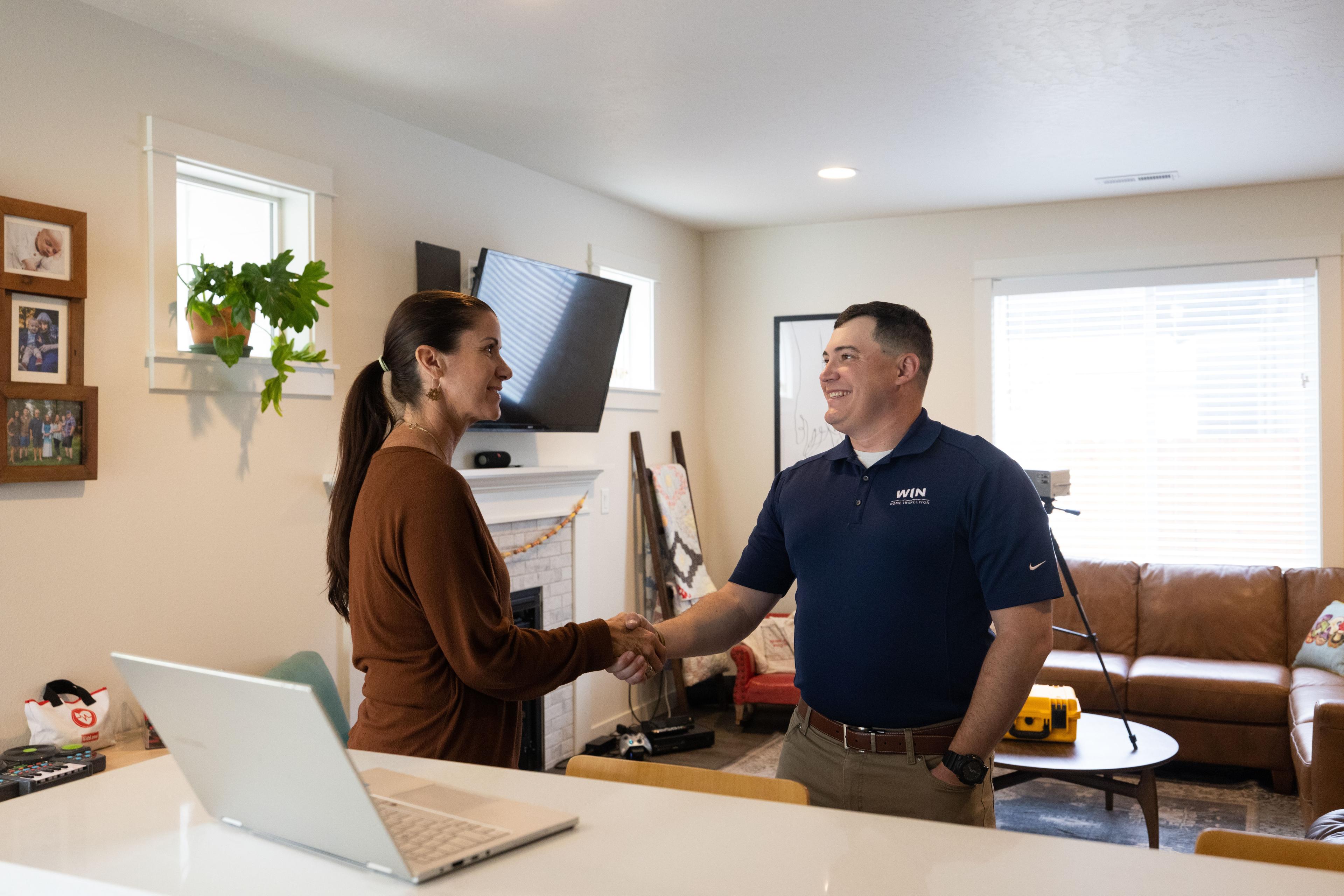 WIN Home Inspector shaking hands with female client in the house.