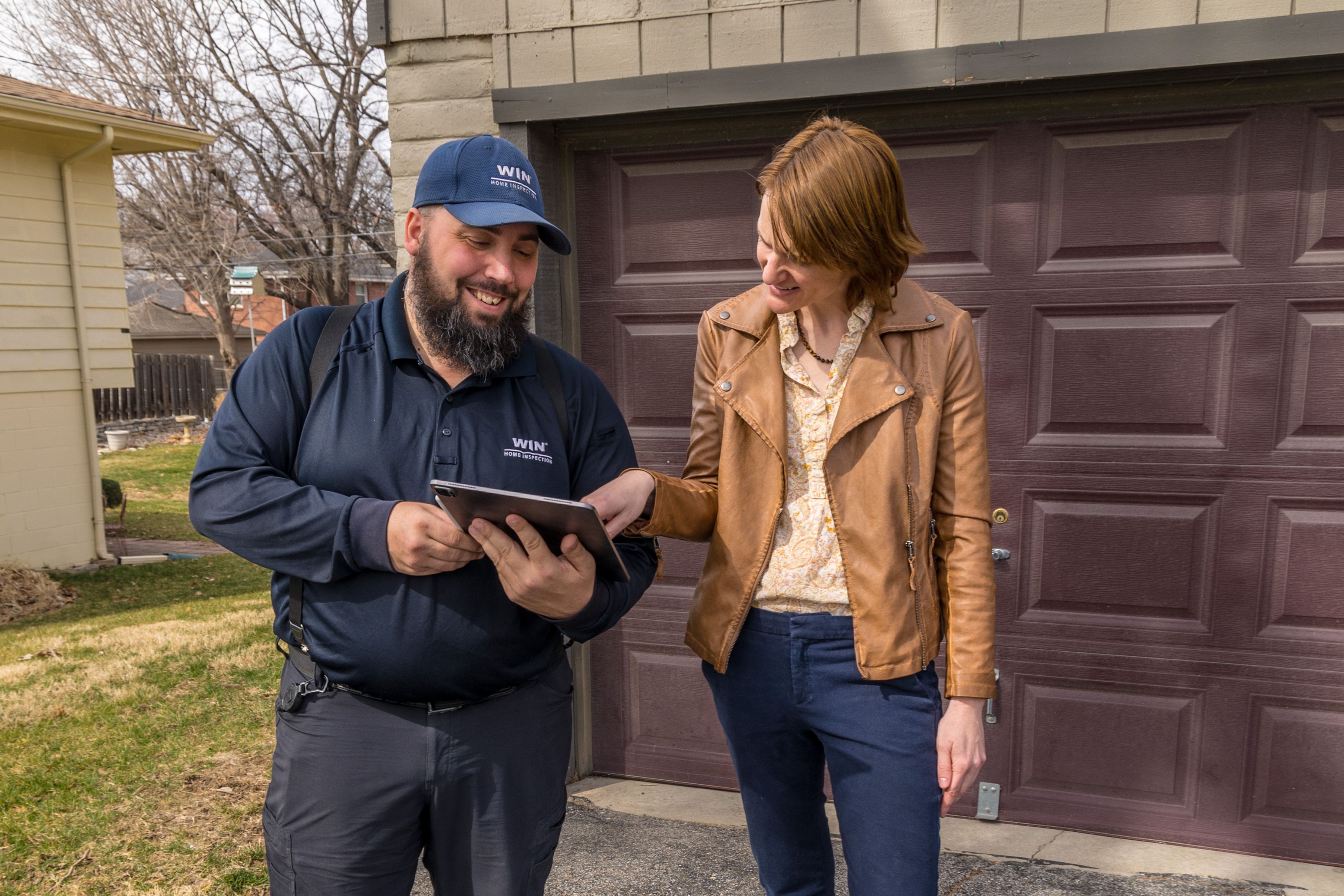 WIN Home Inspector shaking hands with client in front of a house door