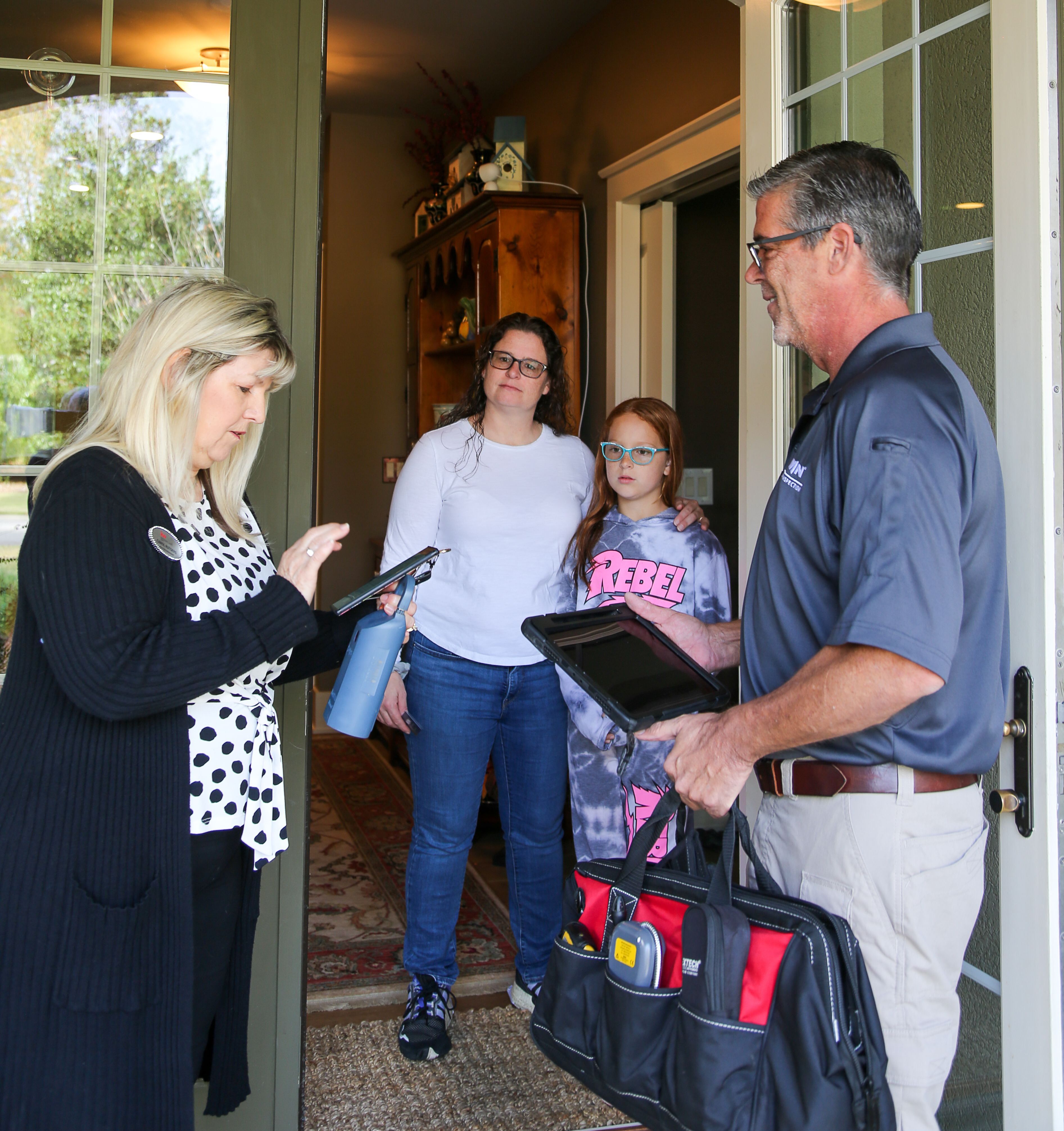 WIN Home Inspector with real estate agent and client in doorway.