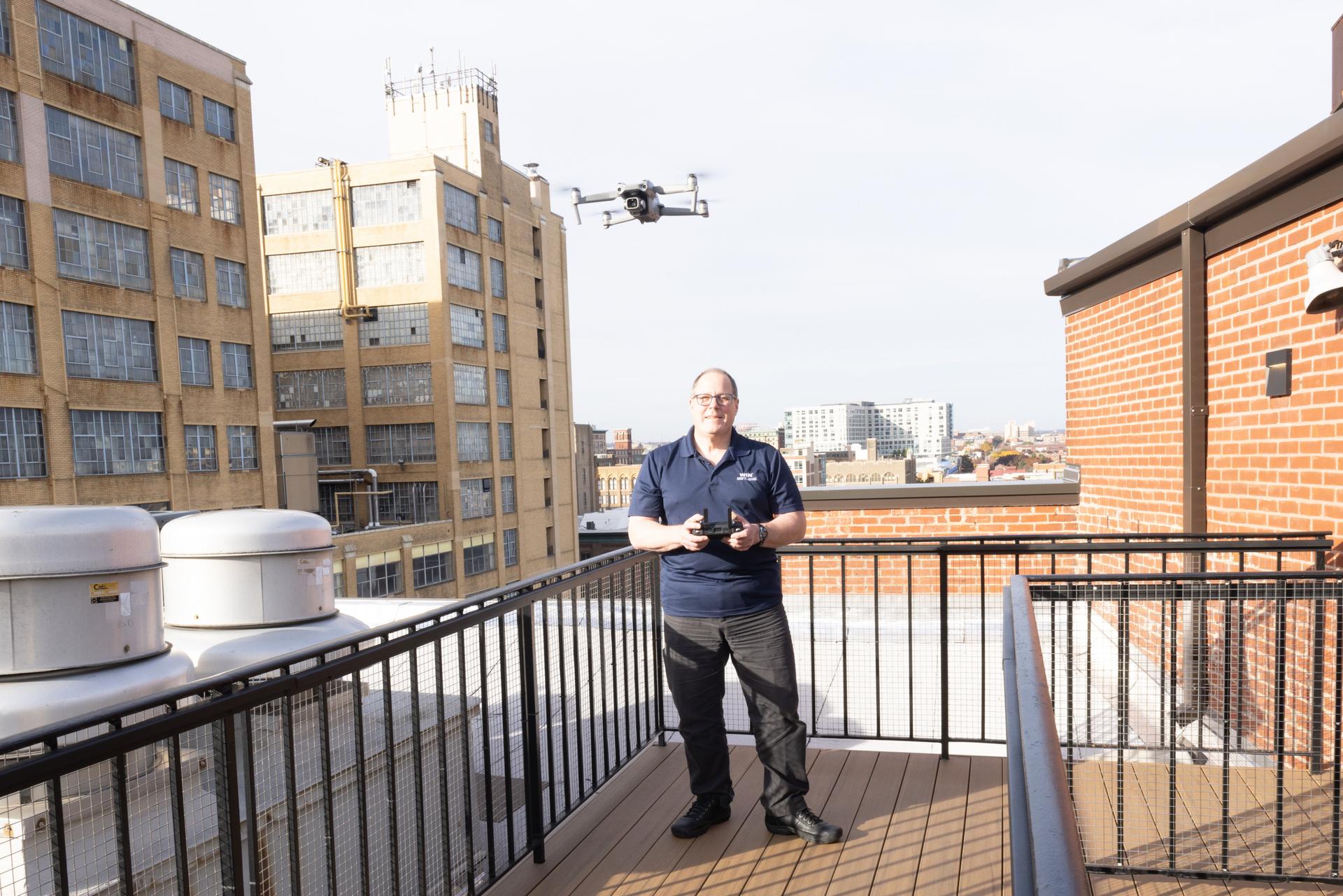 WIN Home Inspector controling a drone on a terrace balcony