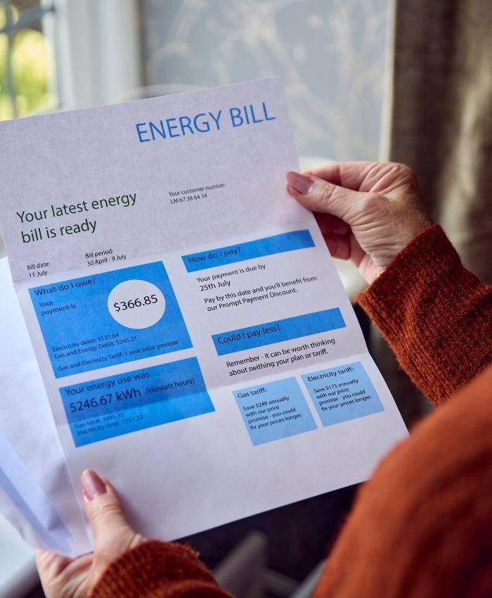 A person holding the house energy bill