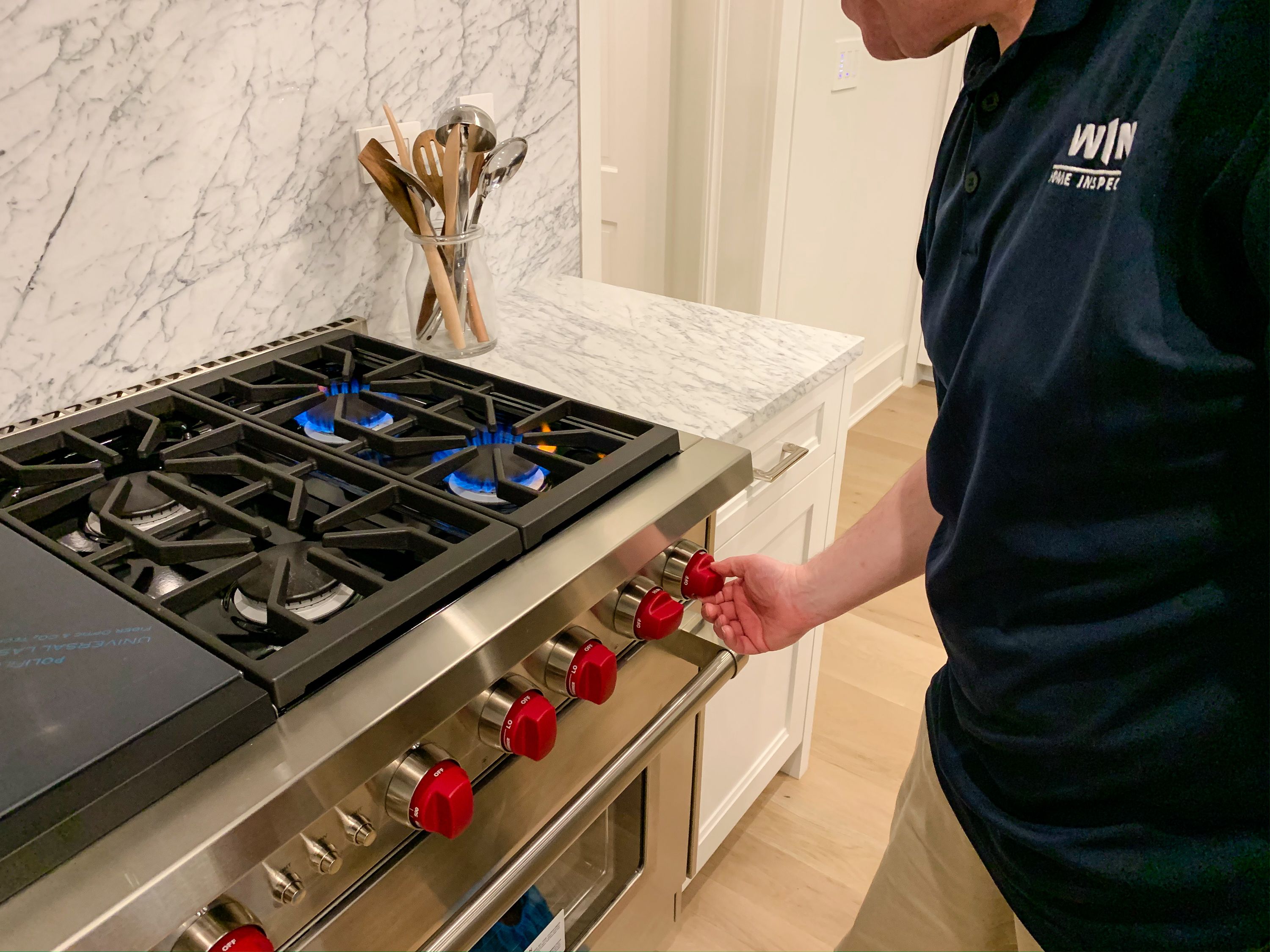Professional WIN Home Inspector examining a kitchen stove.