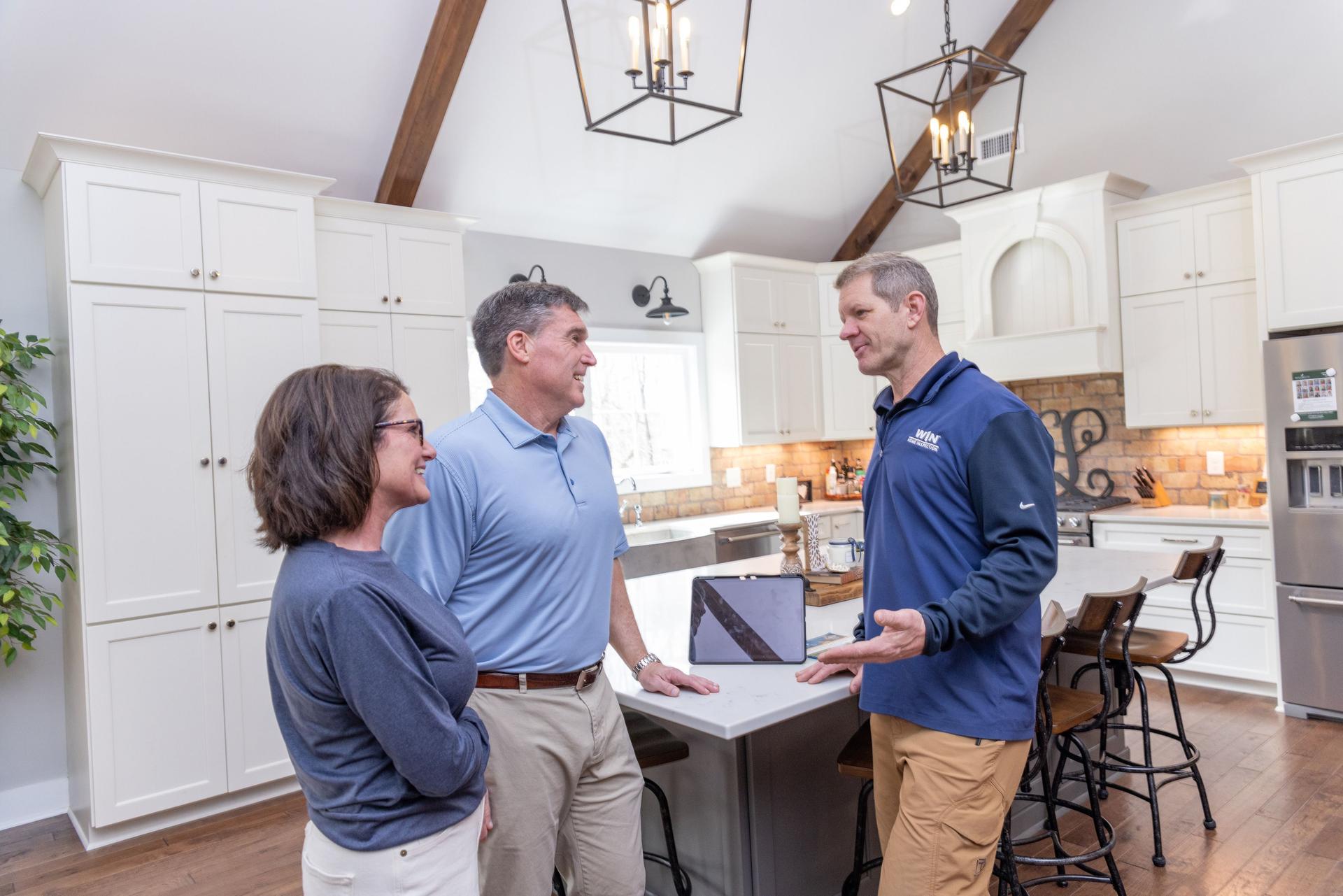 WIN Home Inspector and his clients standing around a kitchen counter