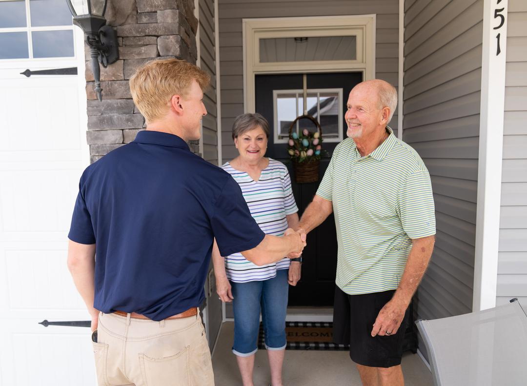 WIN Home Inspector shaking hands with an old man near the home