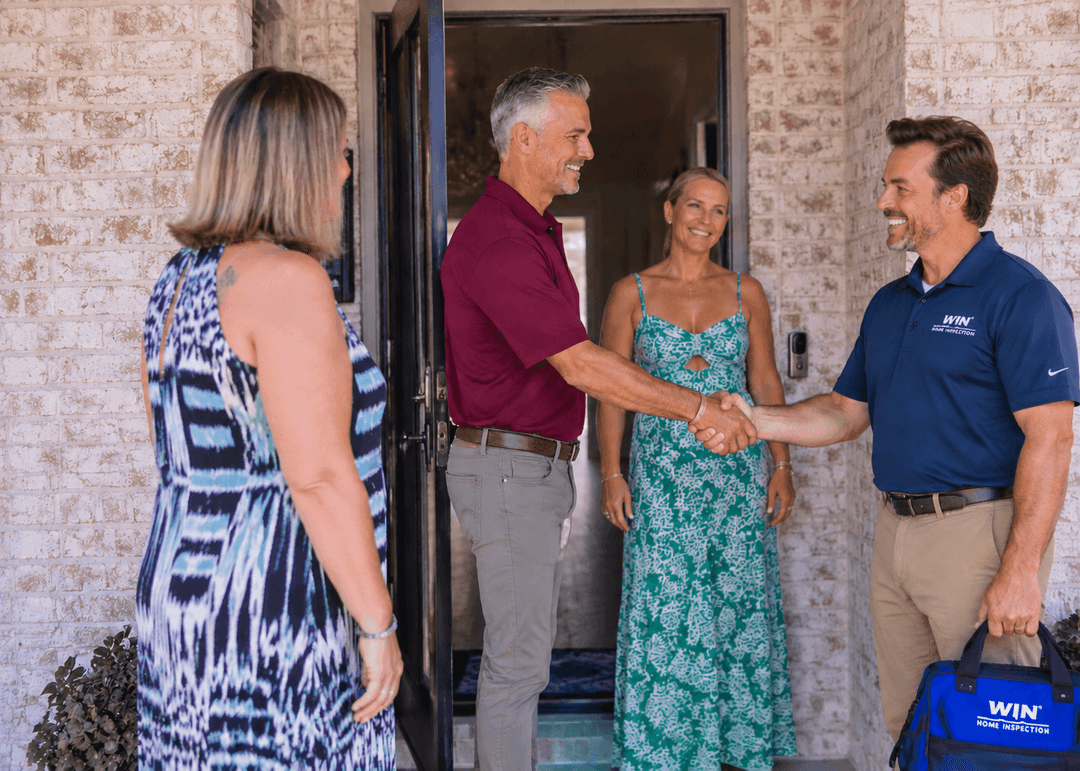 WIN Home Inspector shaking hands with client in front of a house door