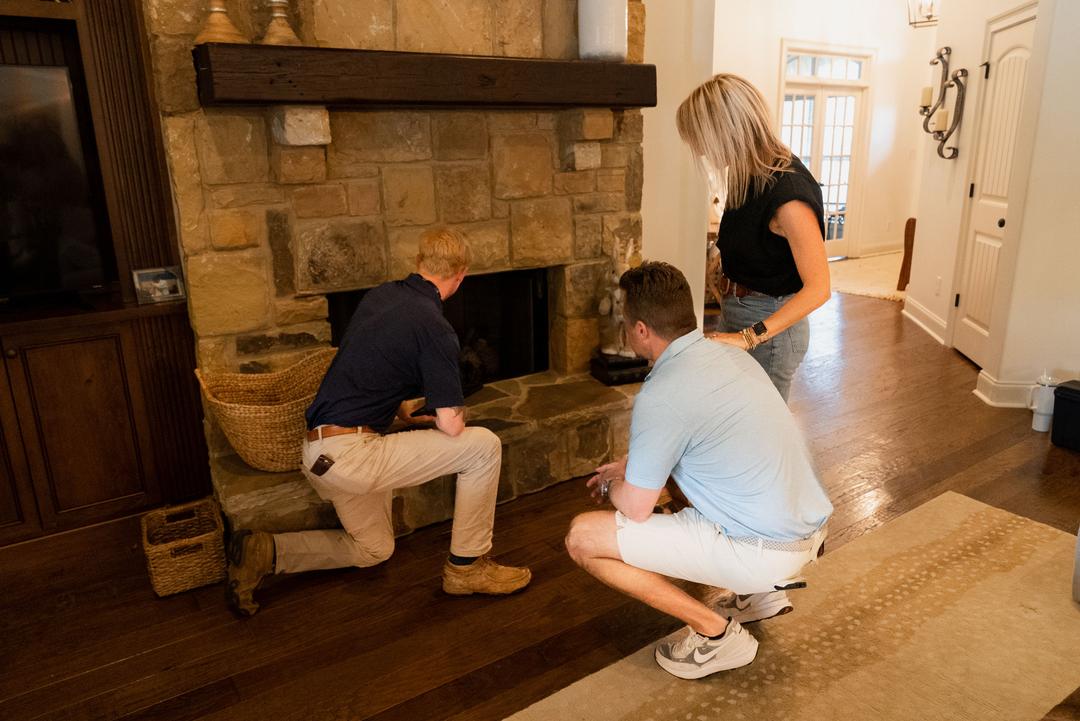 Home inspector checking the fireplace with the clients present
