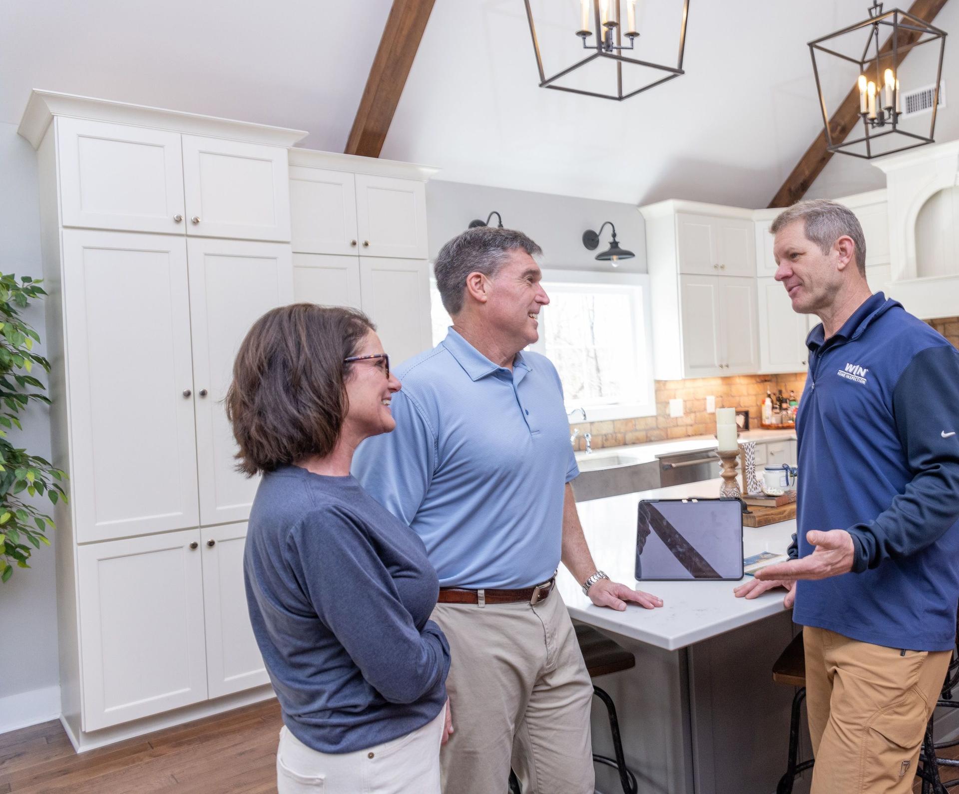 A group of people standing in a kitchen with WIN Home Inspector.