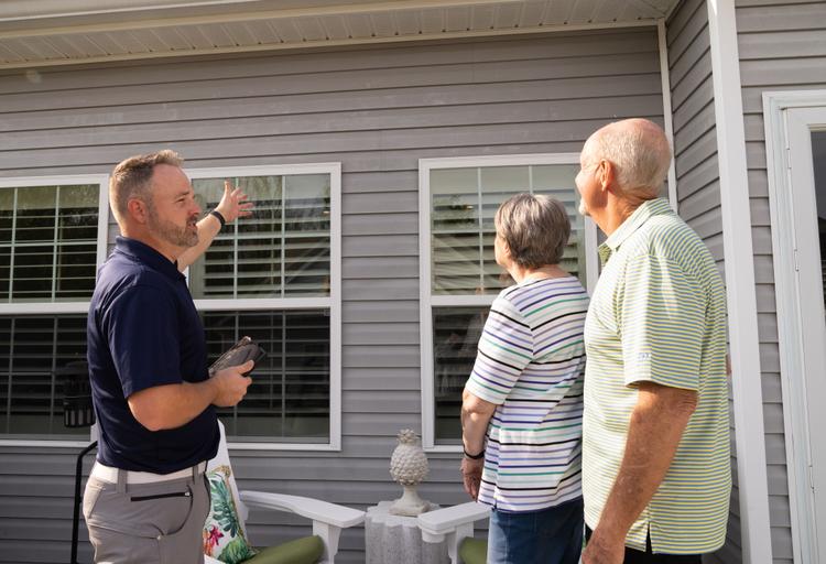 WIN Home inspector talking to the homeowners outside a house