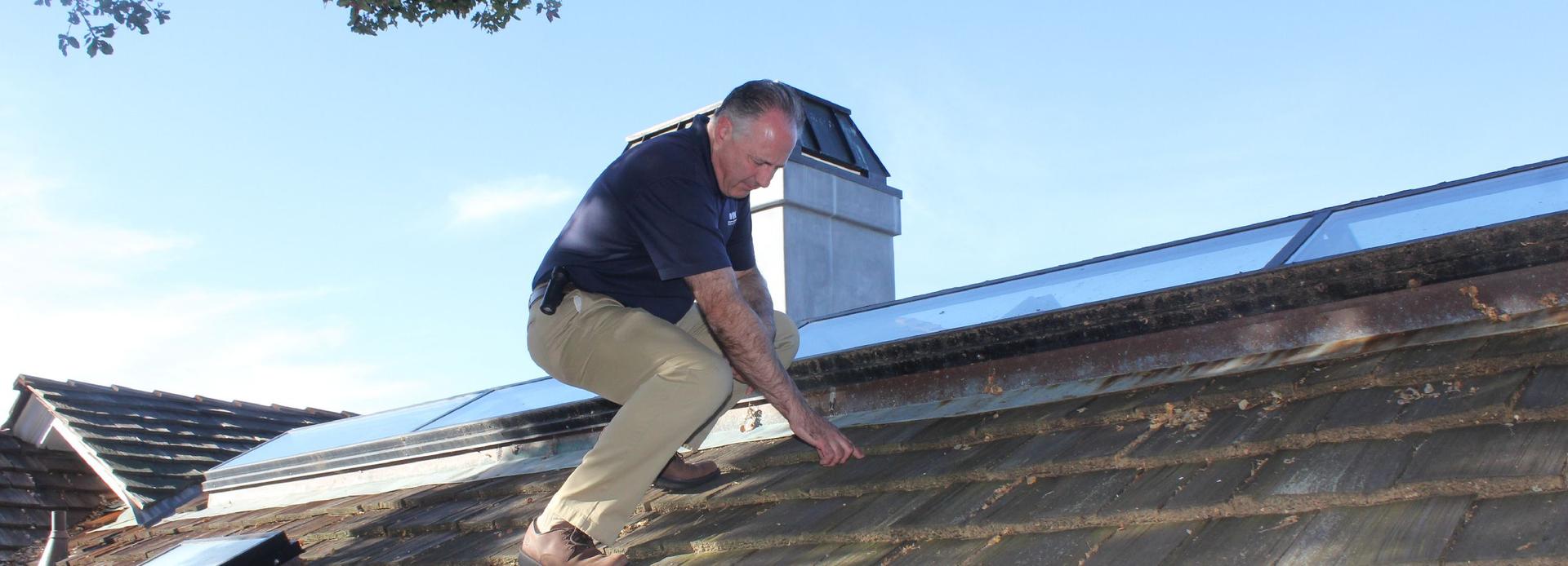 WIN Home Inspector doing asbestos test on the house roof