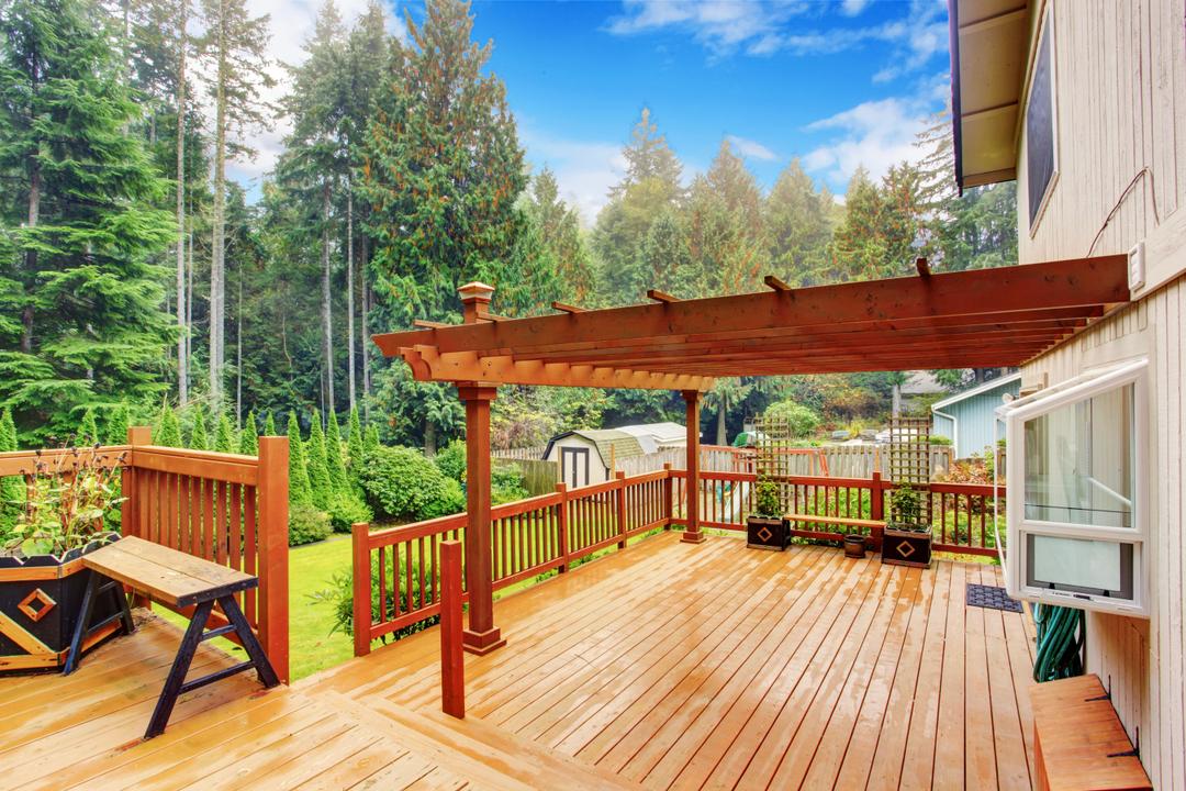 Deck with a pergola and trees in the background