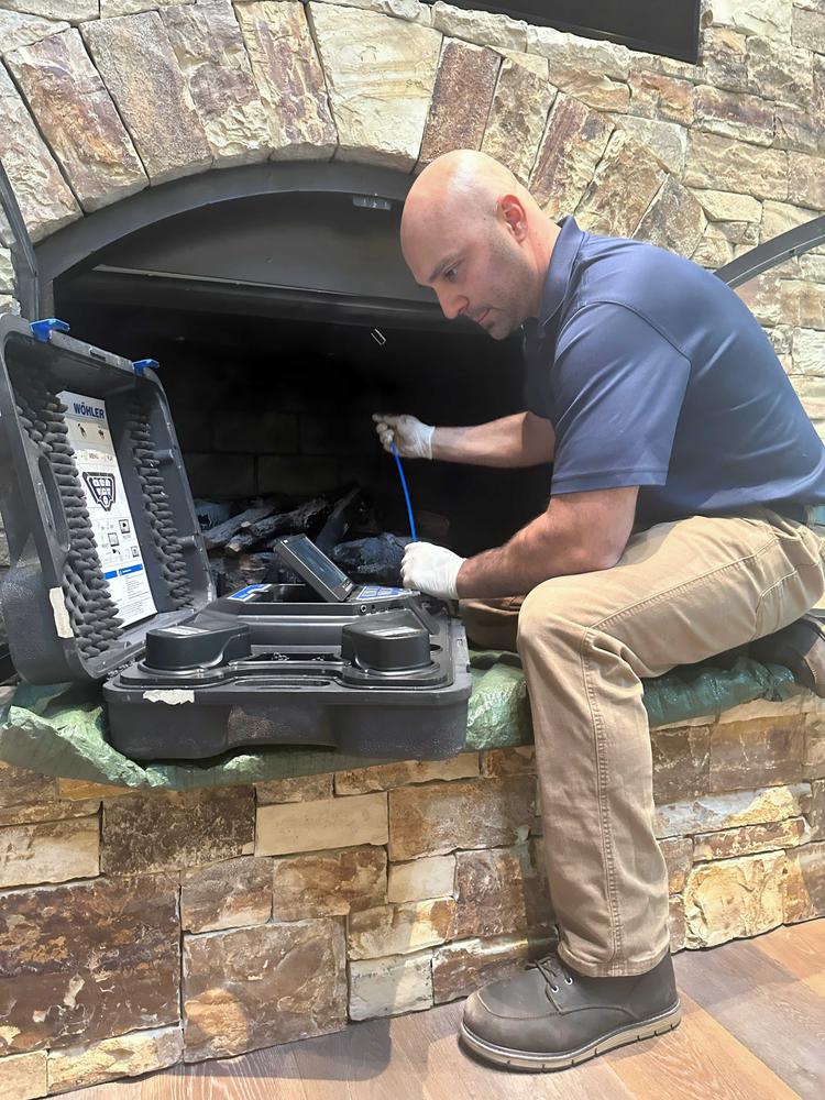 WIN Home Inspector doing a fireplace inspection