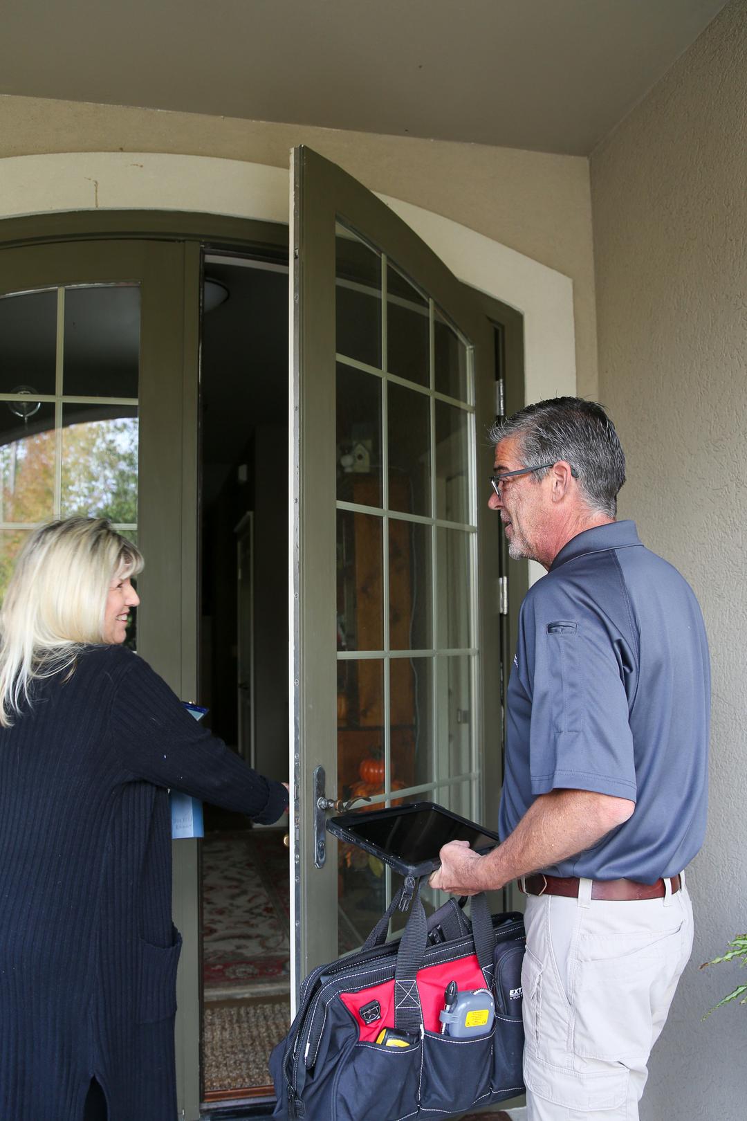 WIN Home inspector and client standing in front of a door