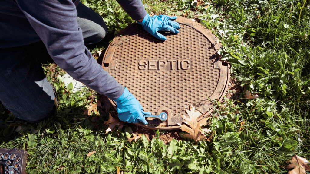 A septic inspector opening septic system tank. 