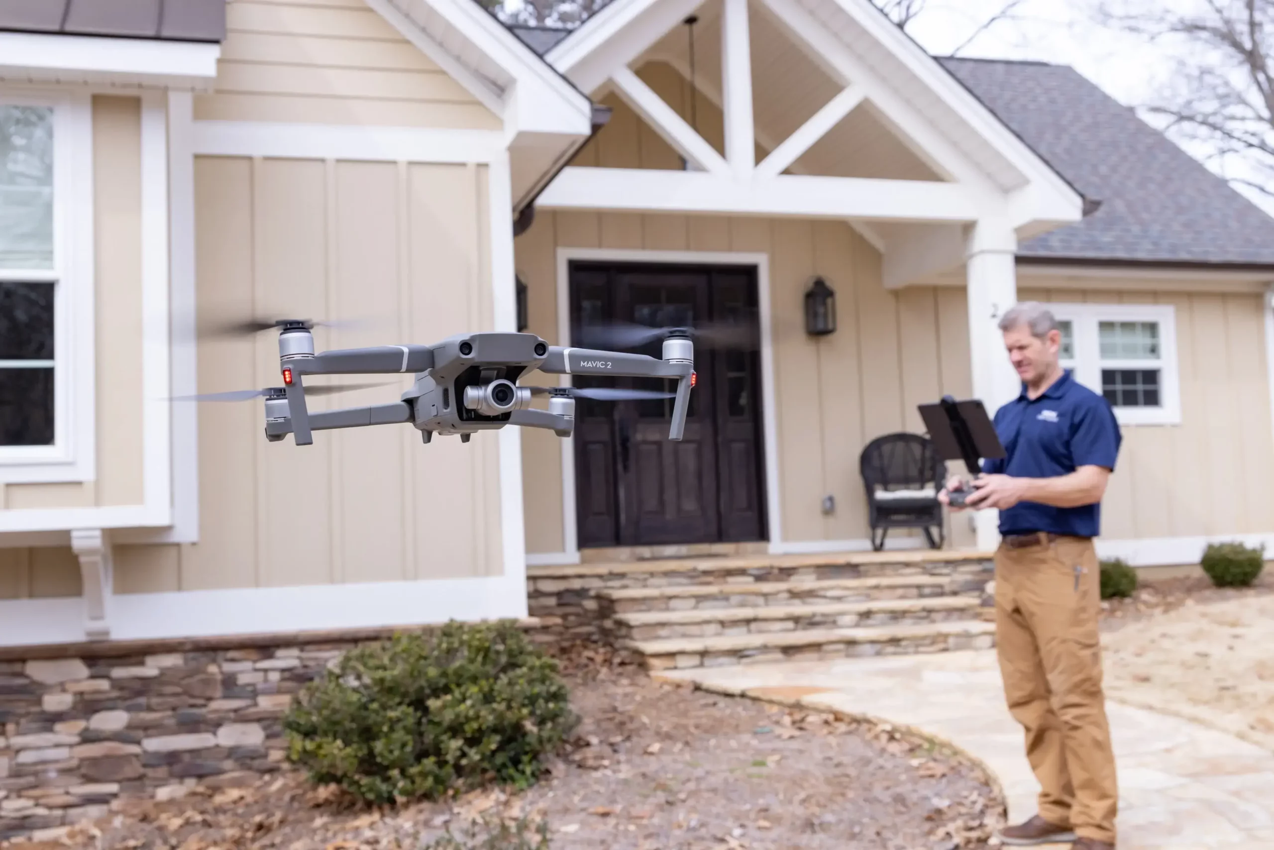Flying drone with a home inspector in background
